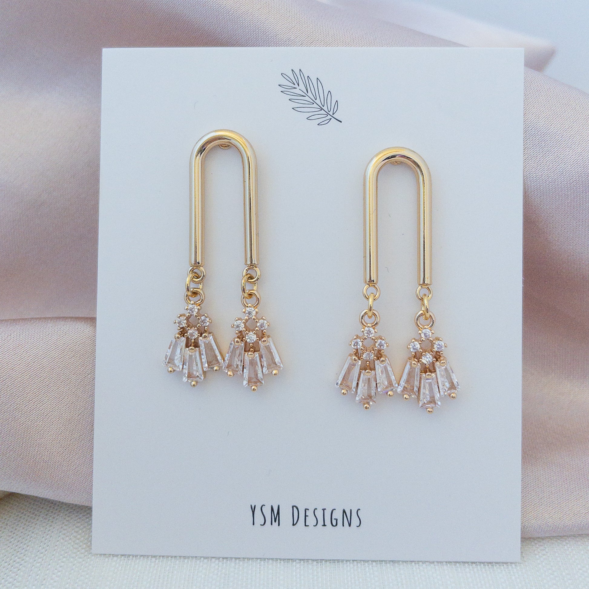 Gold Art Deco style earrings on a necklace card by YSM Designs