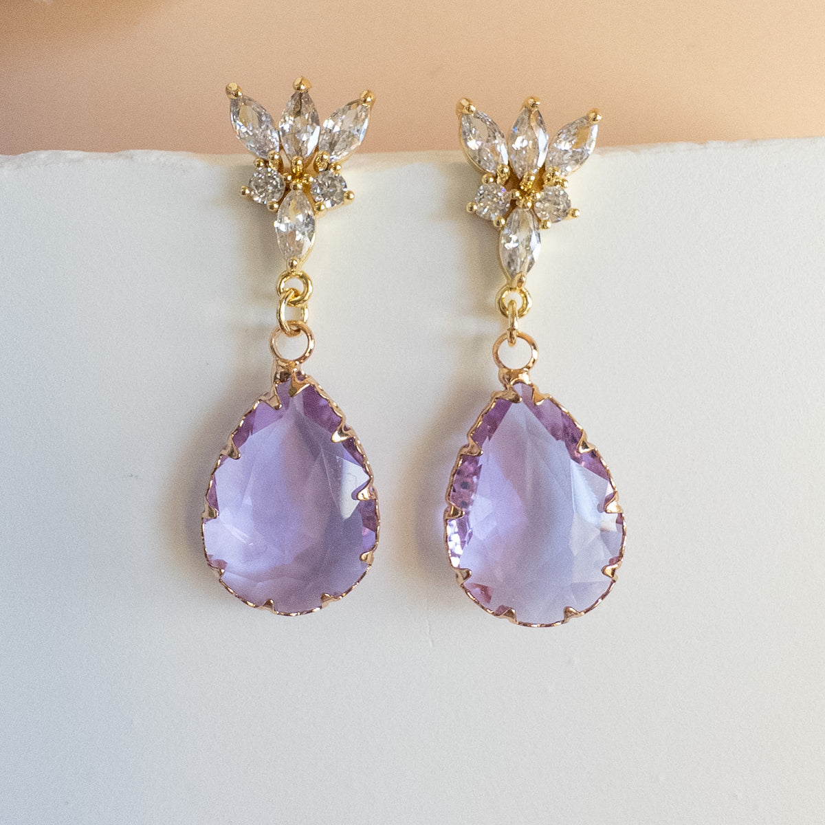 Lavender crystal teardrop earrings with marquise cluster studs on white