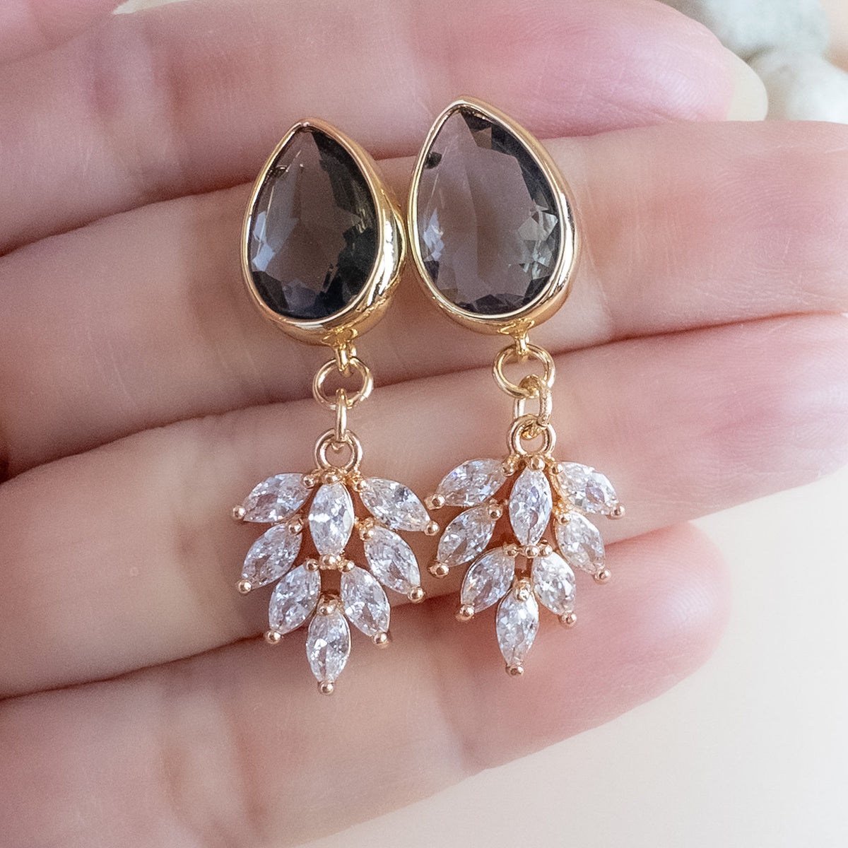 Charcoal crystal drop earrings held in hand to show 1 inch size