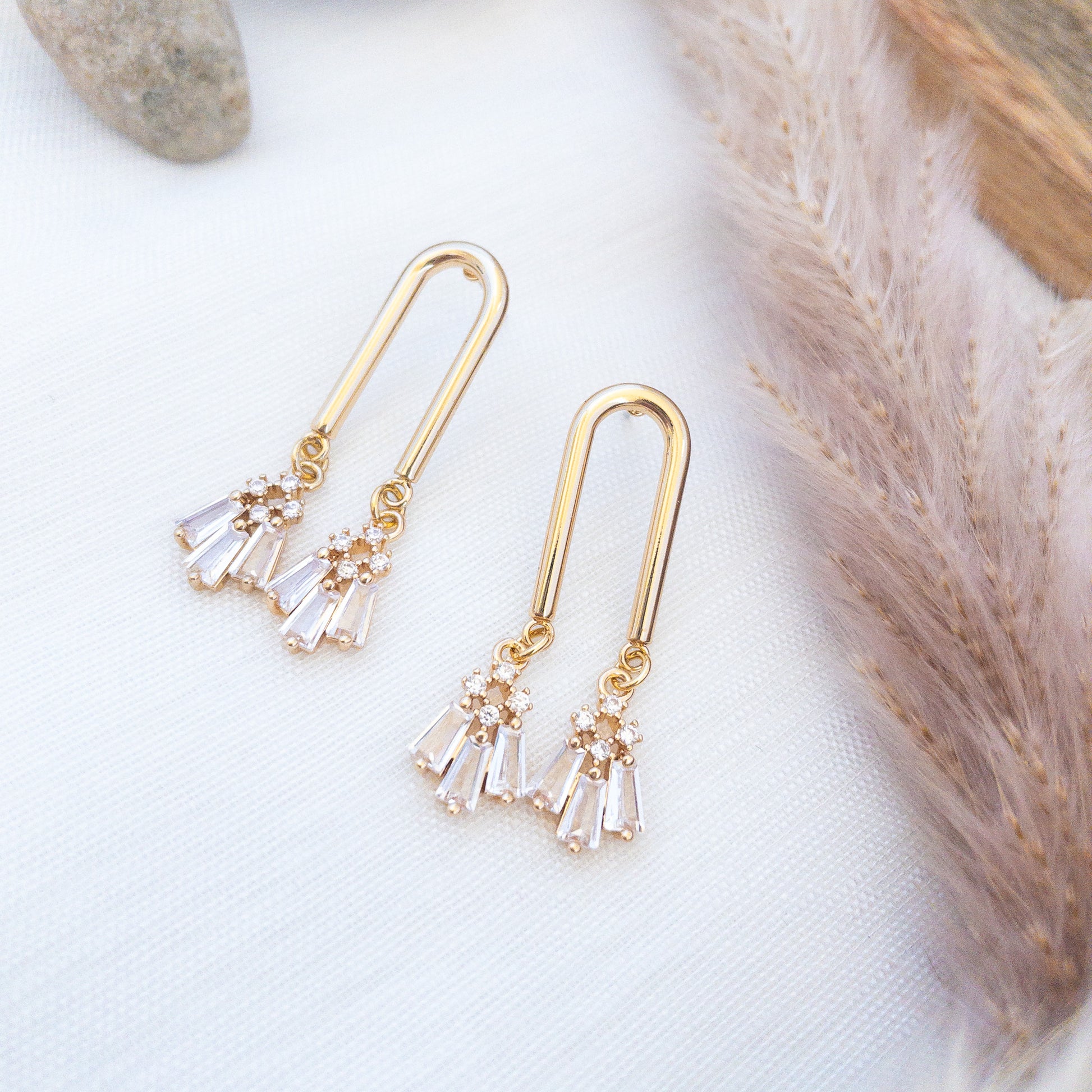 Unique Gold geometric earrings laying on a white surface