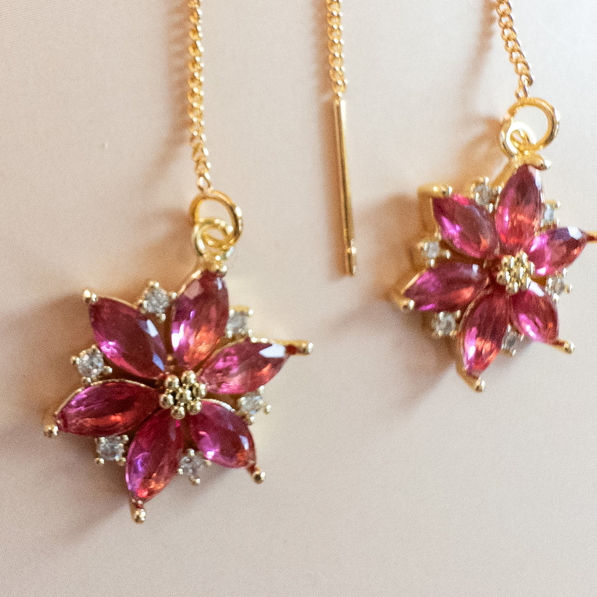 Close-up of cranberry marquise crystal poinsettia with clear accents and beaded gold center