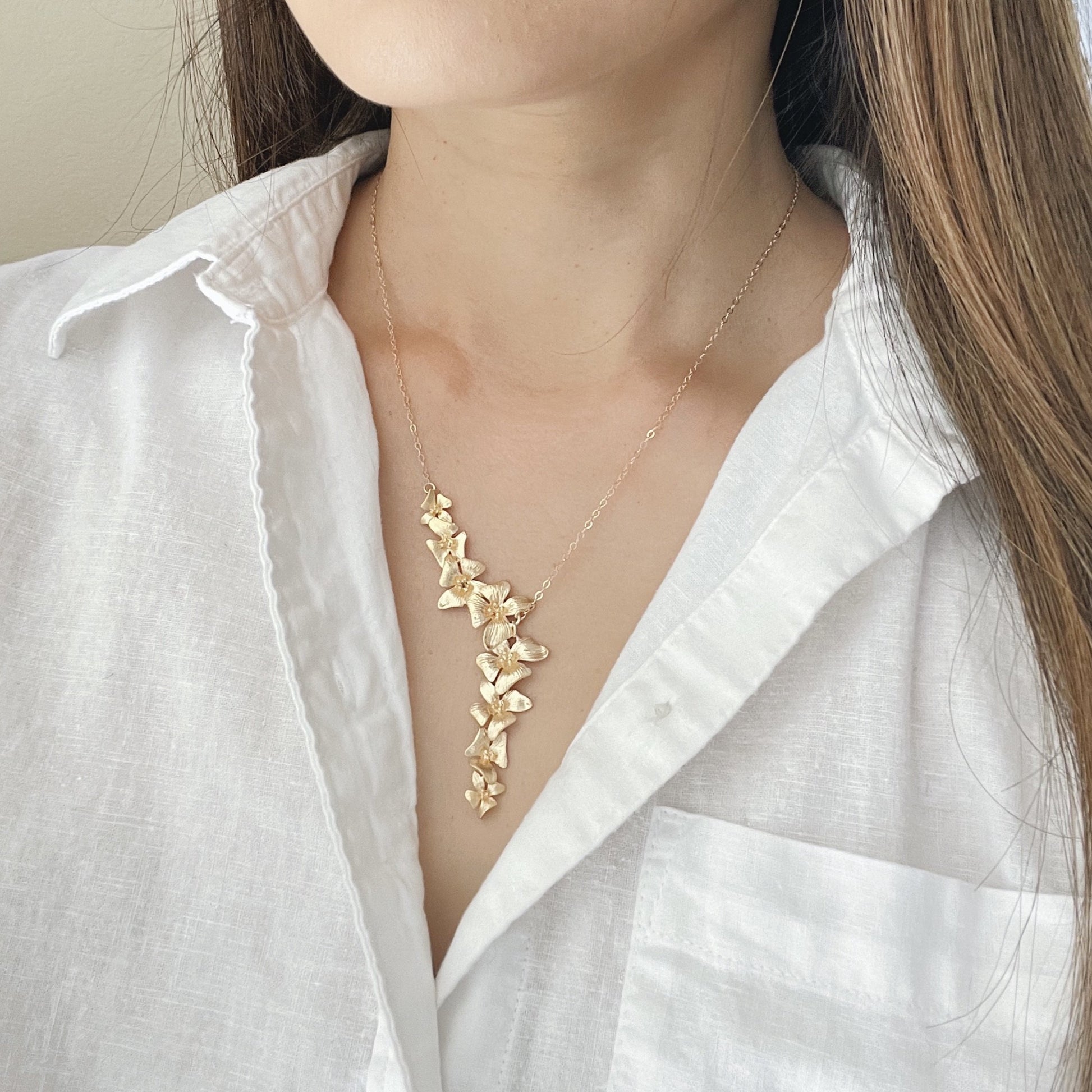 Woman wearing gold y flower necklace