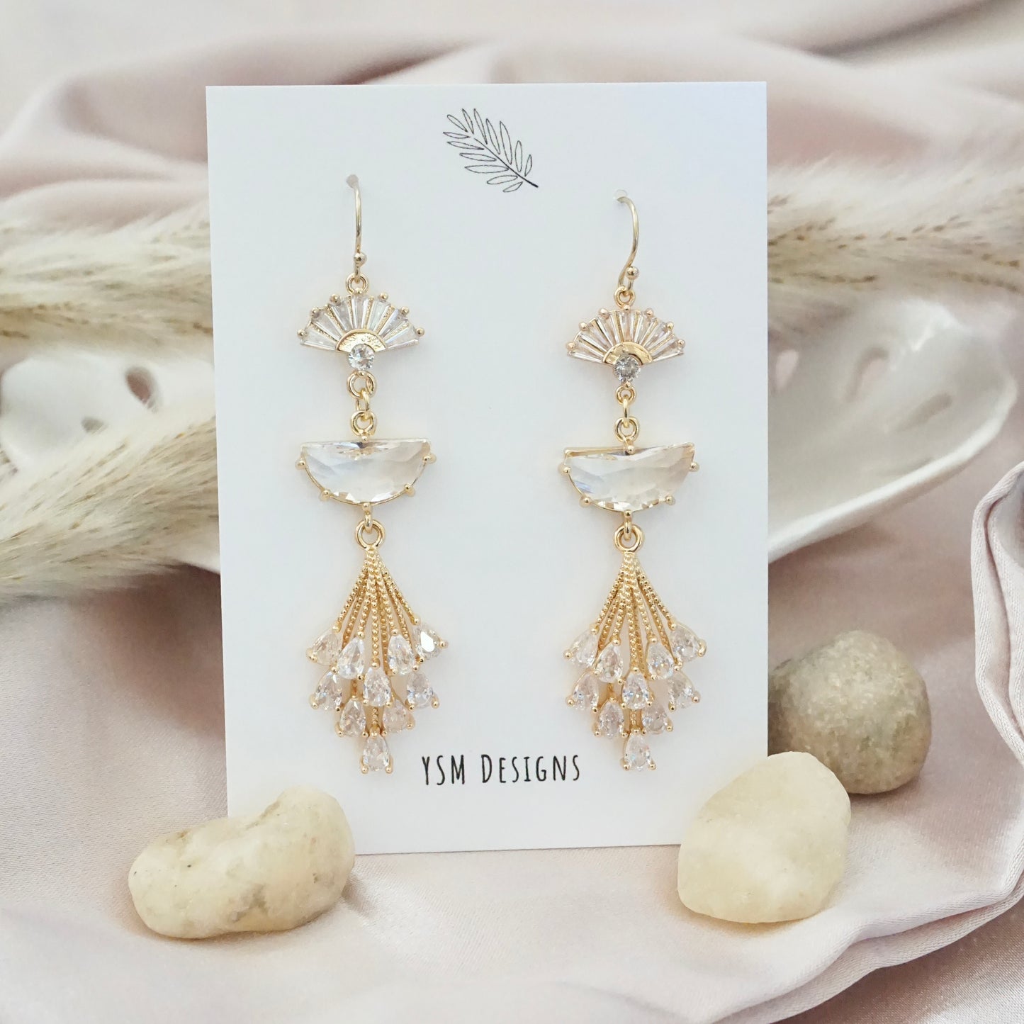 Gold earrings featuring a cubic zirconia fan shaped crystals finished with snowdrop flower inspired crystal piece.