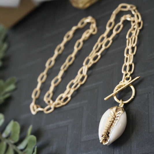 Gold cowrie shell toggle necklace