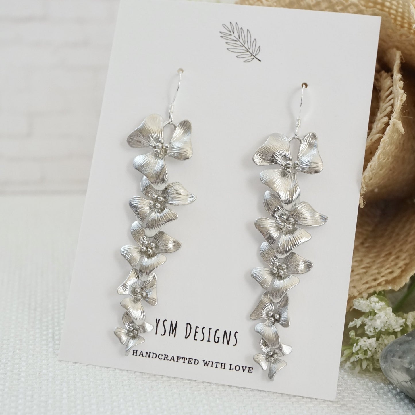 Silver flower earrings on a jewelry card
