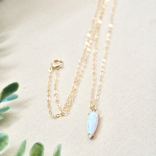 a dainty gold necklace with opal stone in marquise shape