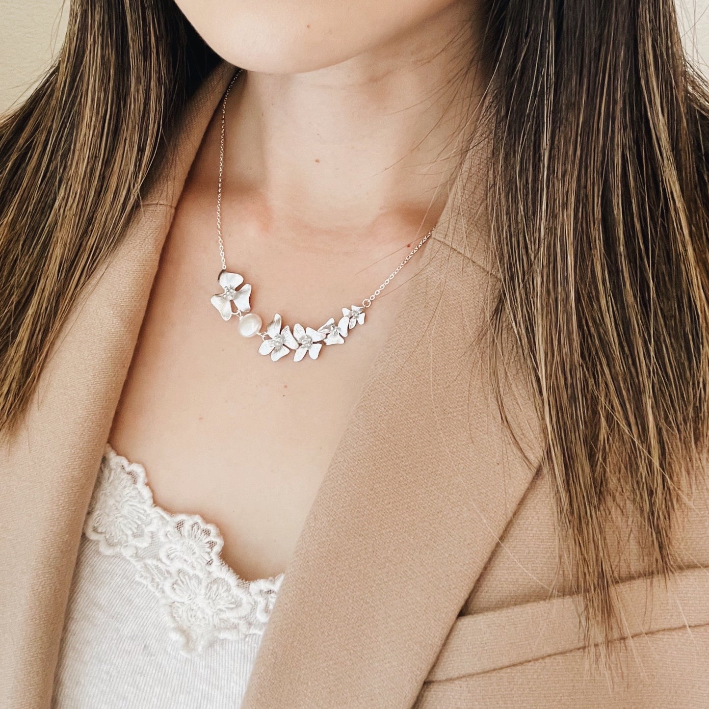 Woman wearing silver dogwood flower necklace