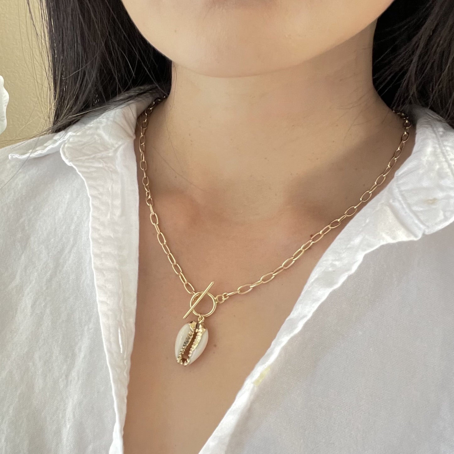 Woman wearing a cowrie shell toggle necklace