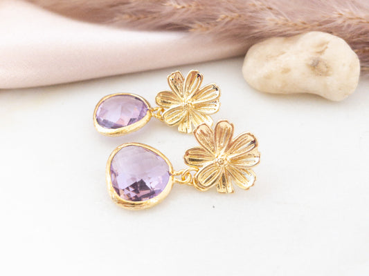 Gold Cherry blossom post earrings with lilac crystal stones laying flat on a white surface